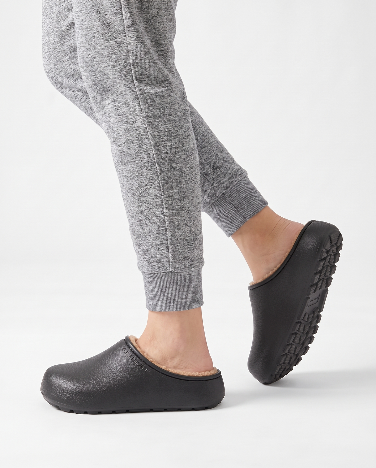 Women's Plush-Lined Winter Clog Slippers in Black – walking view showing the sole